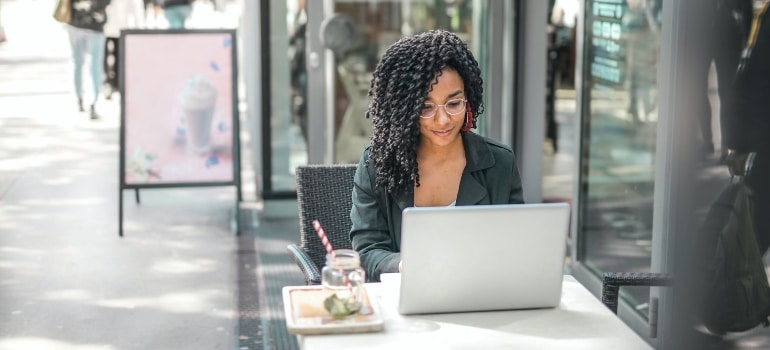 Person sitting in a cafe and looking at her laptop