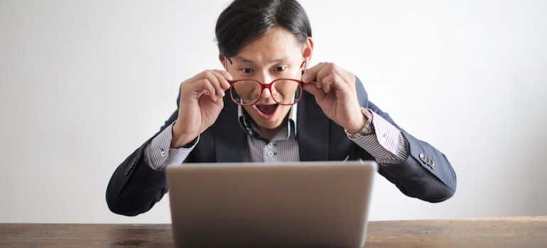 Man looking at a laptop screen and being surprised