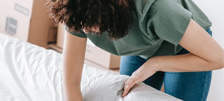 a woman wrapping furniture in waterproof covers for a spring move