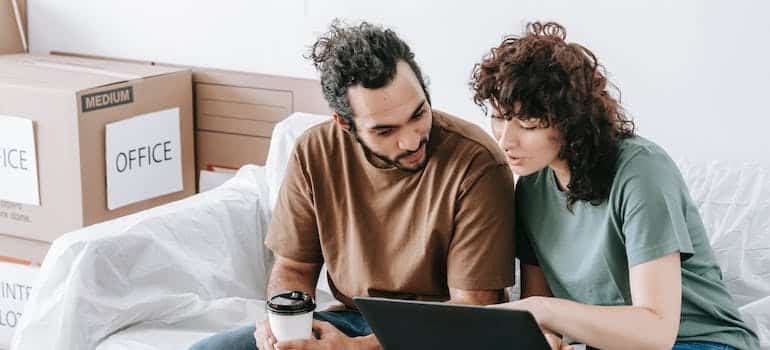 A couple using a laptop to look for moving quotes