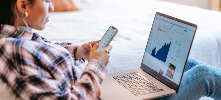 A person using a phone and laptop