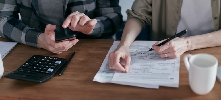 Two people examining an agency's reputation after consulting the guide to avoiding deceptive agency practices