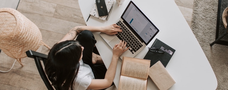 Woman using a laptop and notebook