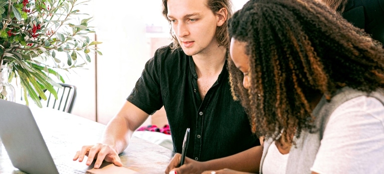A man and a woman looking at a laptop