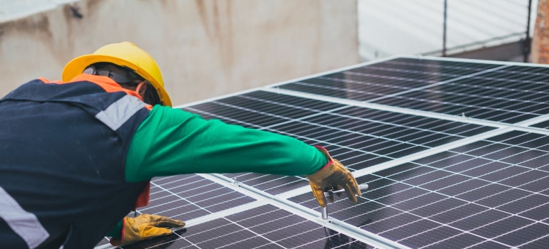 a person fixing solar panels