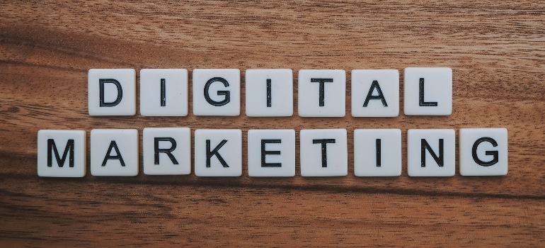 Tiles spelling "DIGITAL MARKETING" on a wooden desk. 