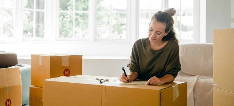 A woman packing her boxes.