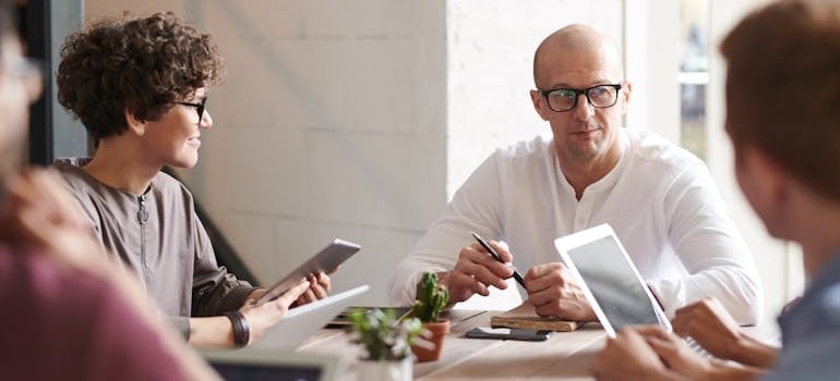 A group of managers talking about startup costs for a moving company