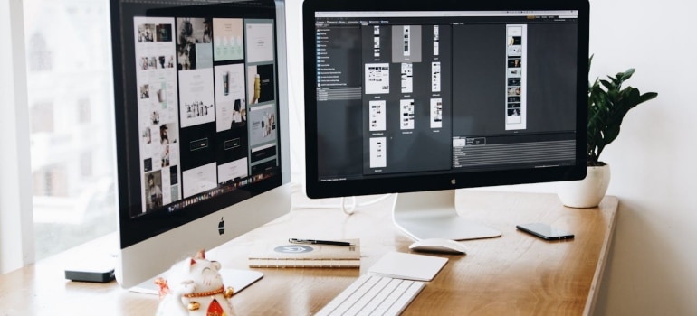 two white computers on the desk 
