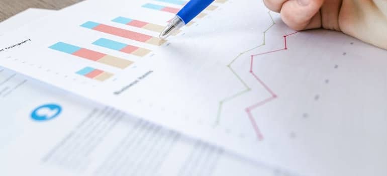 A person analyzing graphs, trying to calculate the hidden costs of a bad moving experience