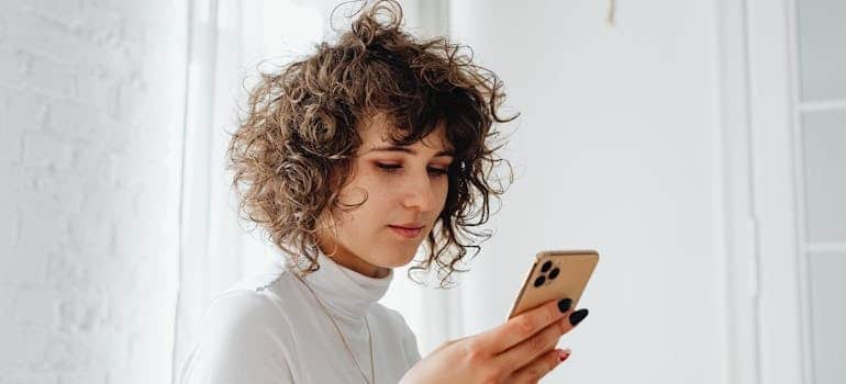 A person using a smartphone to leave a review regarding their moving experience