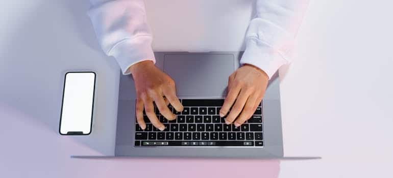 A person using a laptop to do online research and learn how to turn tax refunds into moving bookings