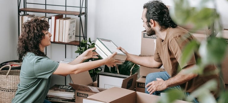 Two people packing their items for moving