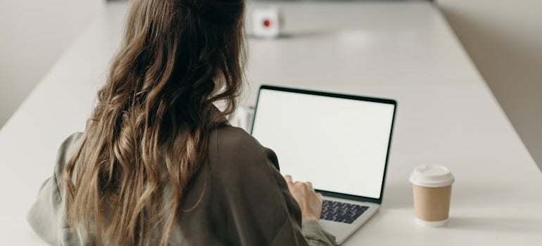 A person using a laptop to write high-quality content after learning how moving companies can show up in ChatGPT search results